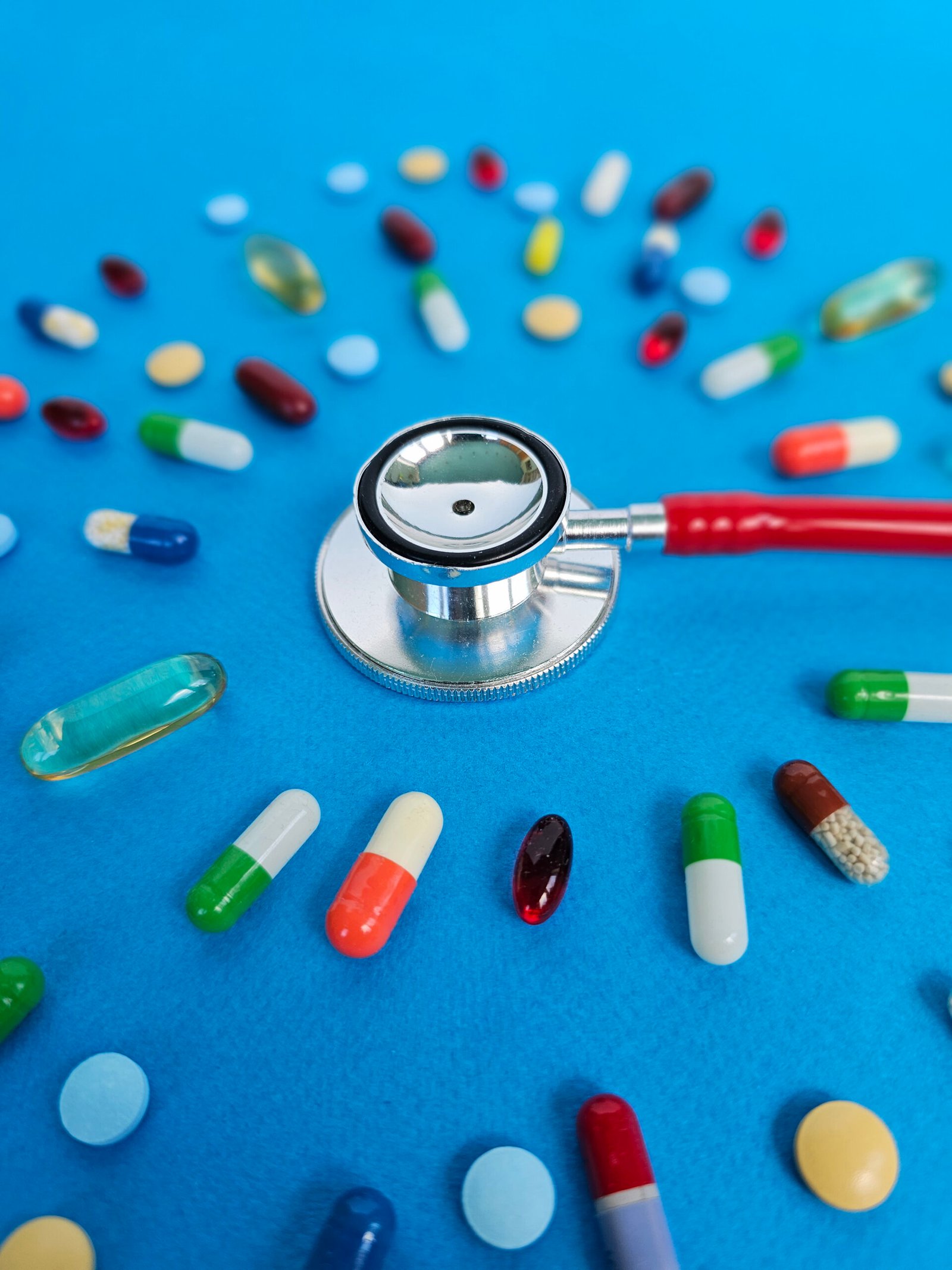 Health tools and medications create a vibrant display on a blue surface, showcasing the importance of healthcare and wellness today